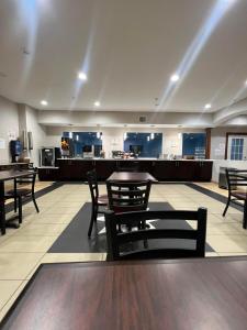 a lobby with tables and chairs and a kitchen at Crystal Suites in Texas City