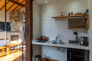 a kitchen with a sink and a stove top oven at Monte Mauá Chalés in Visconde De Maua
