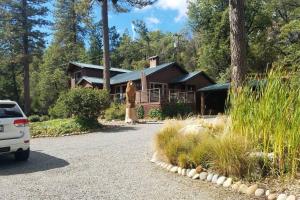 a house with a large bear statue in front of it at Uncle Grizz's Cabin...get intouch with nature in Bass Lake Annex
