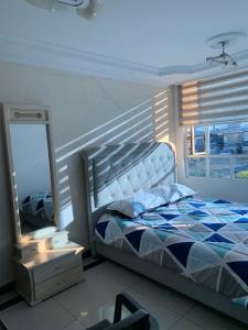 1 dormitorio con cama, espejo y ventana en Habitación Queen, en Bogotá