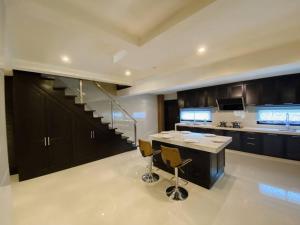 a large kitchen with a counter and a staircase at C02 EuroStyle Seri Alam Homestay in Masai