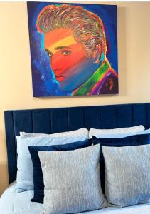 a painting of a woman is above a bed at Luxury Midtown Flats near Downtown Memphis & FedEx Forum in Memphis