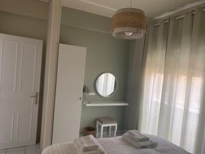 1 dormitorio con cama y espejo en White elephant second floor apartment, en Volos