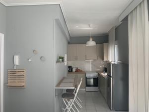 una pequeña cocina con mesa y nevera en White elephant second floor apartment, en Volos