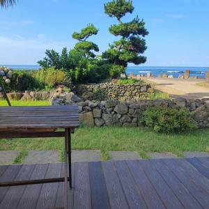 a wooden bench sitting on top of a wooden deck at Sea and Noeul Healing House in Seogwipo