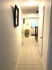 um corredor com piso em azulejo branco e uma porta em Niagara Sleeps 6 Amazing 3bed 3bath minutes to falls em Thorold