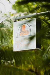 una señal para un complejo de playa y un restaurante colgando de un poste en Amami Beach Resort, en Puerto Galera