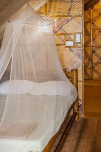 a bed with a mosquito net in a room at Amami Beach Resort in Puerto Galera