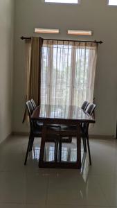einen Tisch und Stühle in einem Zimmer mit Fenster in der Unterkunft Homestay Omah Venus in Jenggrik
