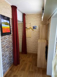Zimmer mit roten Vorhängen und Ziegelwand in der Unterkunft C. Leuci in Hannover