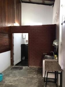 uma cozinha com um lavatório e uma parede de tijolos em บ้านสุขใจ (Ban Suk Jai) 