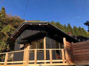 een hut met een houten hek ervoor bij １日1組様限定　「ほしな屋」 in Nagano