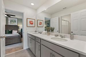 a bathroom with two sinks and a large mirror at Sea Shore at Solara Resort by Shine Villas #401 villa in Orlando