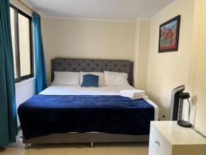 1 dormitorio con 1 cama grande con manta azul en Lovely apartment in the best zone of Medellin en Medellín