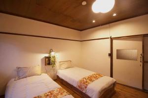 長野的住宿－1日1組様限定　「ホシナサトマチ 」，一间卧室设有两张床,天花板上拥有灯光
