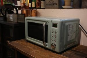 a silver microwave sitting on top of a wooden table at 1日1組様限定　「ホシナサトマチ 」 in Nagano