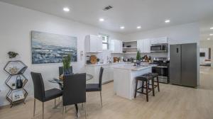 eine Küche mit weißen Schränken sowie einem Tisch und Stühlen in der Unterkunft Vibrant Blue Luxury Apartment 2316 in New Orleans