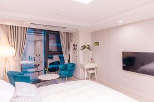 a bedroom with a bed and a table and chairs at Lotte Castle Marina in Yeosu