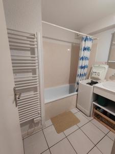 een kleine badkamer met een bad en een wastafel bij Villa "les jardins de saint palais sur mer" in Saint-Palais-sur-Mer