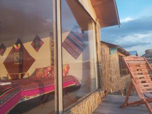 a window of a room with a bed on a balcony at Titicaca Utama Lodge Perú in Puno