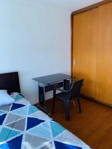 Schlafzimmer mit einem Schreibtisch, einem Bett und einem Tisch in der Unterkunft Bogotá Kings 300 in Bogotá