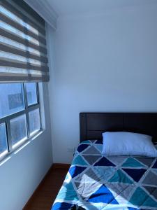 Schlafzimmer mit einem Bett und einem Fenster in der Unterkunft Bogotá Kings 300 in Bogotá