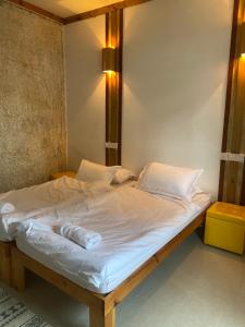 un letto con lenzuola e cuscini bianchi di Holiday Home Himmafushi a Himmafushi