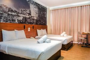 Habitación de hotel con 2 camas y mesa en Hotel María Luisa, en Lima