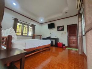 a bedroom with a bed and a television in it at Chatchawan Resort in Ban Tha Sao