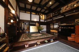 a large room with a rug on a floor with a table at Iroriyado Hidaya in Takayama