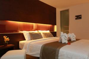 a hotel room with two beds with towels on them at The Bangkok Airport Link Suite - SHA Plus in Bangkok
