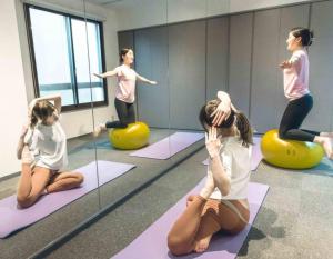 a group of people doing yoga in a room at TenangTenang-Izu Oceanic Villa- in Futo
