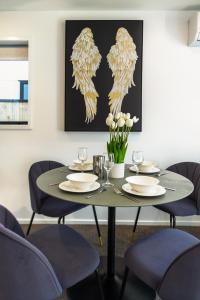 a dining room table with plates and wine glasses at Central City Awaits 2 bed 2 bath with carpark in Christchurch