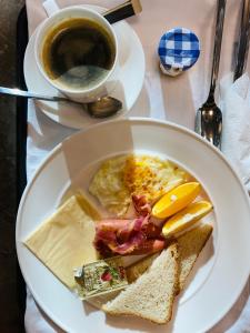 einen Teller mit Eiern, Toast und einer Tasse Kaffee in der Unterkunft Mazaalai Hotel 