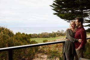 un homme et une femme debout sur une clôture dans l'établissement RACV Inverloch Resort, à Inverloch