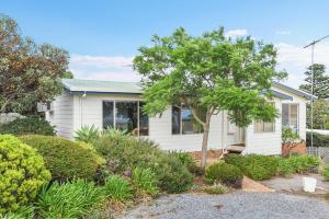 een klein wit huis met een boom in de tuin bij 24 Wilson Drive, Normanville in Normanville