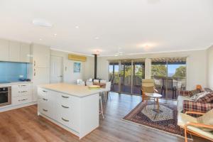 een keuken en een woonkamer met witte kasten en een bank bij 24 Wilson Drive, Normanville in Normanville