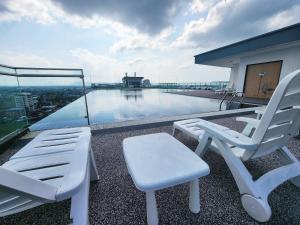 a balcony with two chairs and a pool on a building at Kozi Square Twin Room with free Wi-fi & Carpark in Kuching