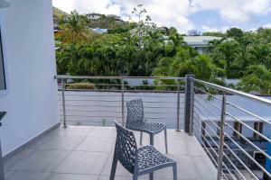 two chairs sitting on the balcony of a house at Modern 3BR Home with Own Private Pool in Philipsburg