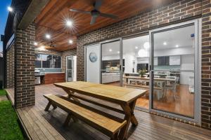 a patio with a wooden table and a dining room at Casa Di Mare - Portarlington in Portarlington