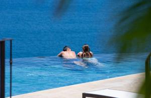 Ein Mann und eine Frau sitzen im Pool in der Unterkunft 360 Splendor 309-Ocean View Residence-Breakfast Included! in Playa Flamingo