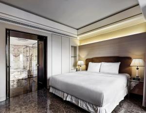 een slaapkamer met een groot wit bed met 2 lampen bij Leofoo Residences in Taipei