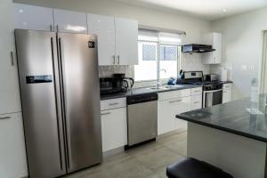 a kitchen with a stainless steel refrigerator and white cabinets at Modern 3BR Home with Own Private Pool in Philipsburg