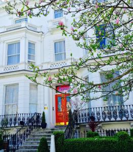 a white building with a red door at Blue Bells Hotel in London