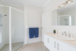 a white bathroom with a sink and a shower at Ray's Beach House at 58 Ocean Parade Middleton in Middleton