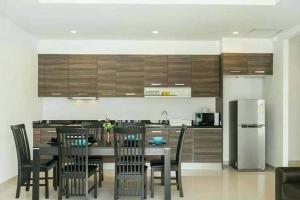 a kitchen with a table and chairs and a refrigerator at E villa , private pool villa for your family in Hua Hin