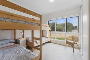 a bedroom with two bunk beds and a window at Ray's Beach House at 58 Ocean Parade Middleton in Middleton