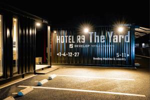 HOTEL R9 The Yard Yuki في Yuki: بوابة في موقف للسيارات في الليل مع وجود أضواء