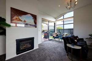 a living room with a fireplace and a couch at Whanau Retreat in Kaikoura