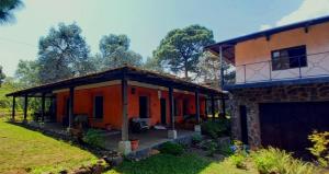 an orange house with a large patio in the yard at Amankaya Atitlan in Cerro de Oro